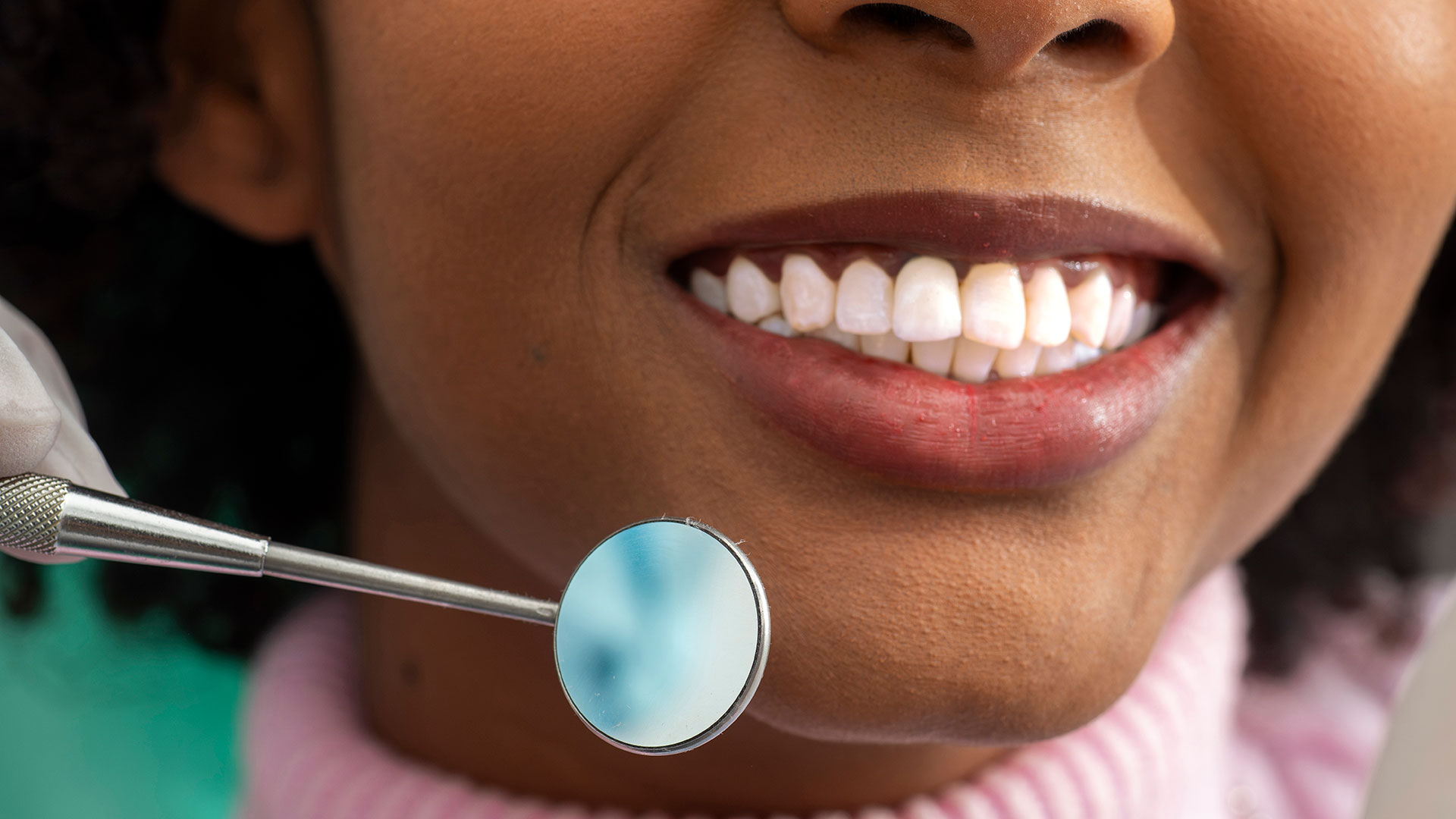 Patient Smiling While Dentist Holds Dental Mirror